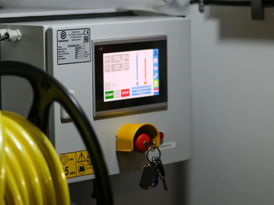 Panel de control con pantalla táctil y parada de emergencia en un equipo industrial