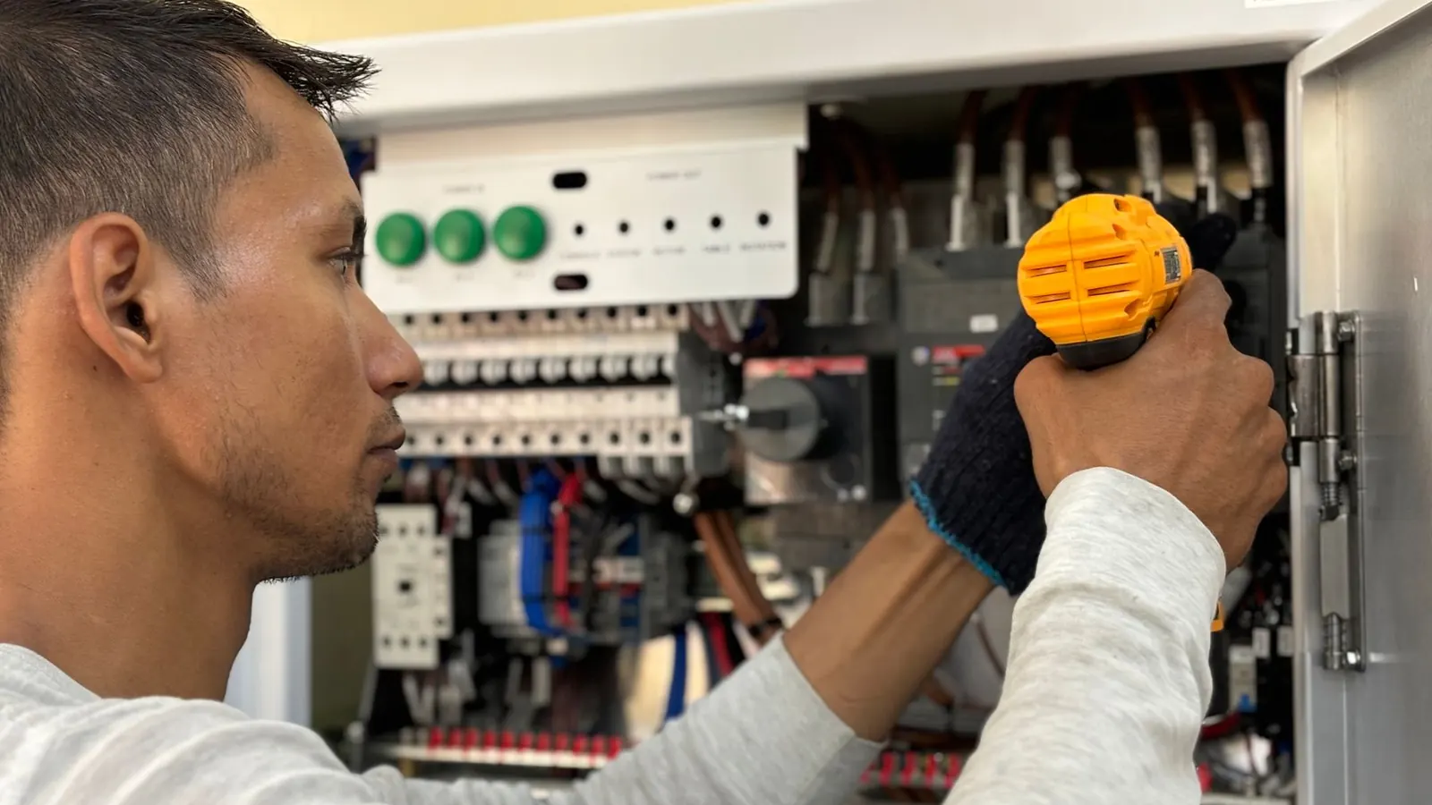 Técnico midiendo con multímetro sobre las borneras de un tablero energizado